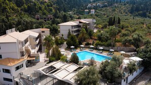 A resort with a swimming pool, outdoor seating, and a view of the surrounding landscape.