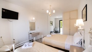 A hotel room with two beds, a desk, a chair, a television, and a wardrobe. - Santa Marina (Lefkada)