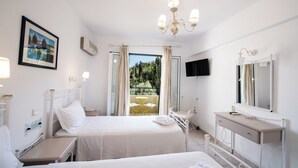 A hotel room with two beds, a desk, a chair, a TV, and a balcony with a view.