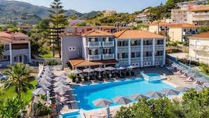 A resort with a swimming pool, multiple balconies, and a view of the surrounding hills. - Anamar Zante Hotel (Zakynthos)