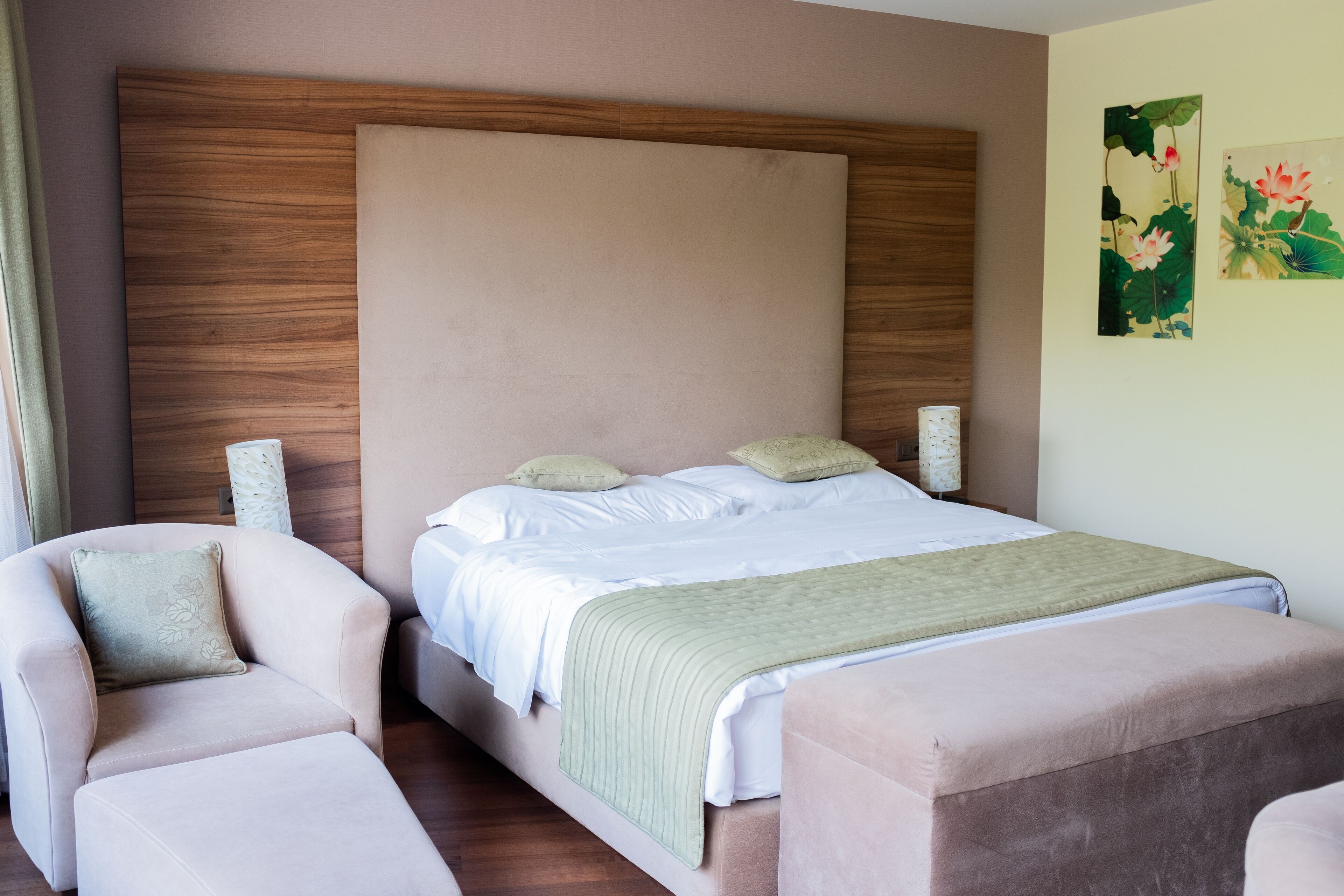 Une chambre à coucher avec un grand lit, deux fauteuils et une table de chevet.