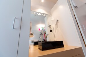 A modern bathroom with a large mirror, a black rectangular object on the counter, and a towel rack. - ibis Styles Lausanne Center Mad House (Lausanne)