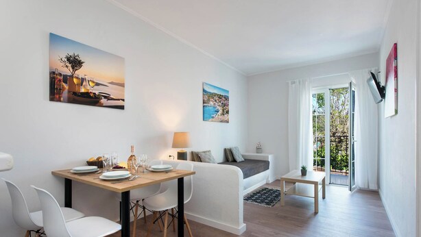 Una sala de estar moderna con comedor, un sofá, una mesita y un balcón con vistas.