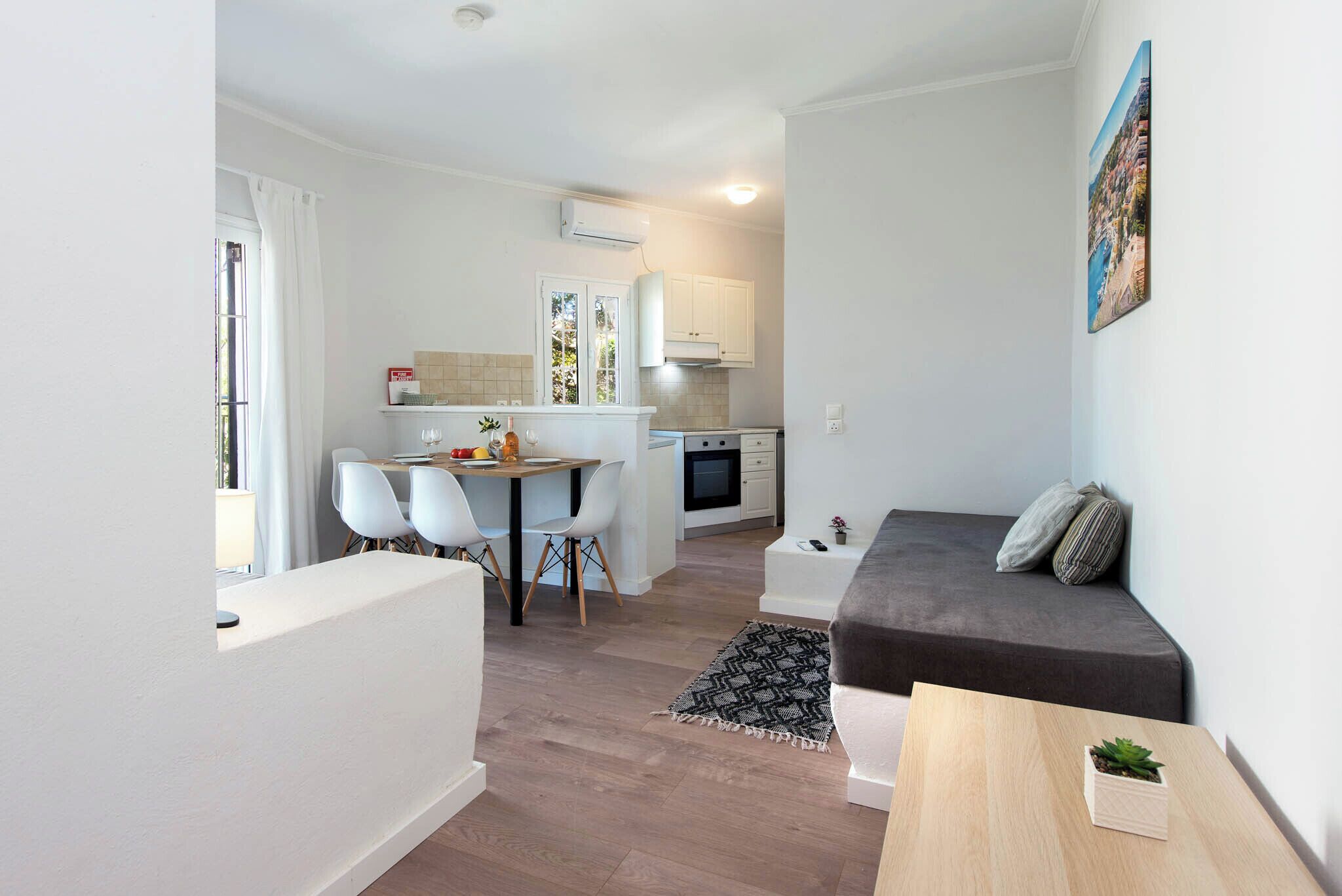 A compact living space with a kitchenette, dining area, and seating area.