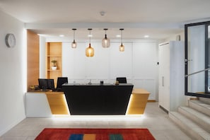 A modern kitchen with a central island, pendant lighting, and a clock on the wall. - Hotel Löwen Am See (Zug)
