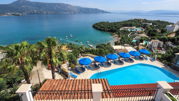 Um resort com piscina, espreguiçadeiras e vista para o mar.