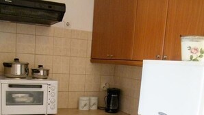 A compact kitchen with a toaster oven, a coffee maker, and a refrigerator. - Agnanti Studios (Kefalonia)