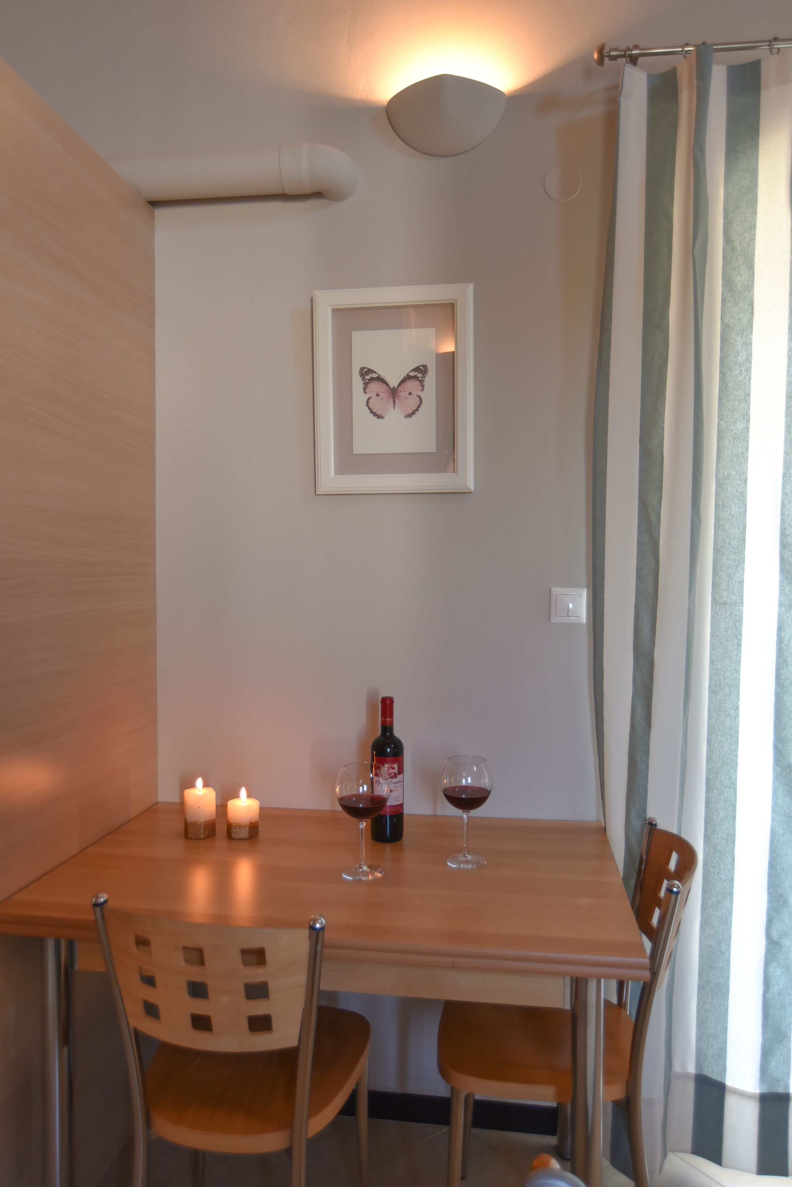 A dining table with candles, a wine bottle, and glasses.