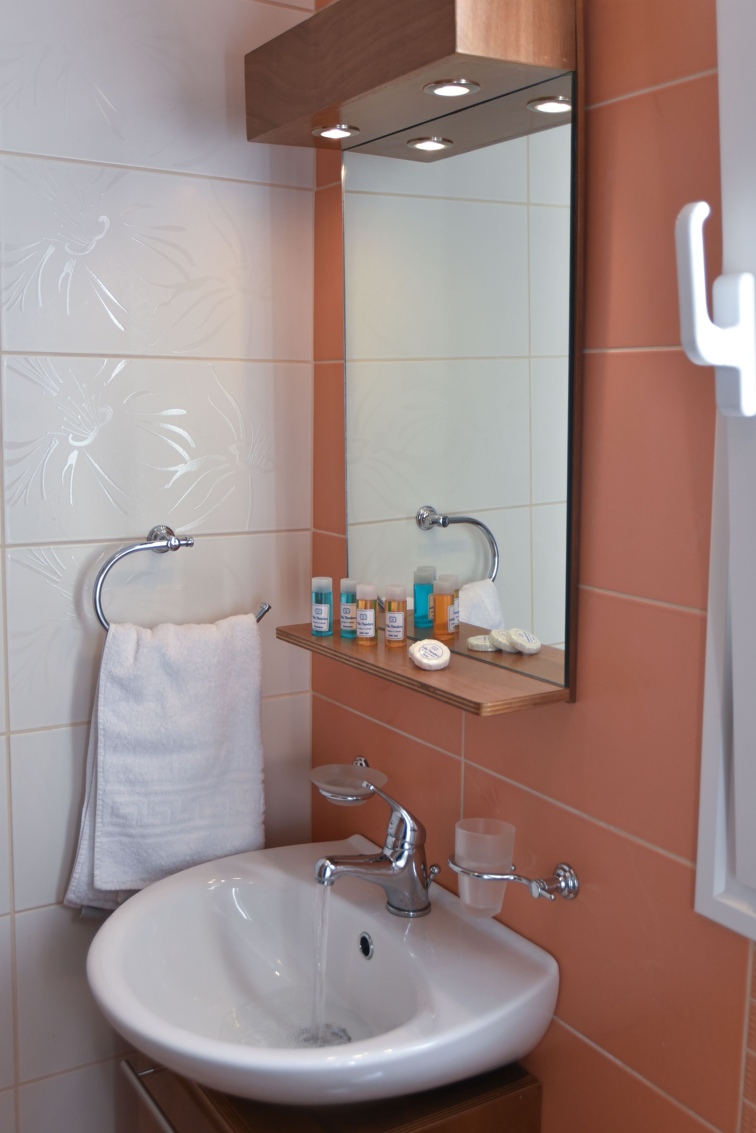 A bathroom with a white sink, a mirror, and a towel rack.