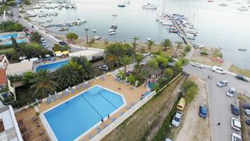 A marina with boats, a swimming pool, and a road with cars.