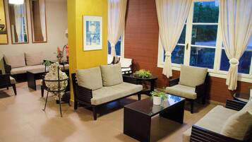 A well-lit living room with a sofa set, a coffee table, and a fireplace.