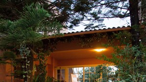 Una escalera con un felpudo que dice 'WELCOME' que lleva a una casa con techo de tejas y plantas en macetas.