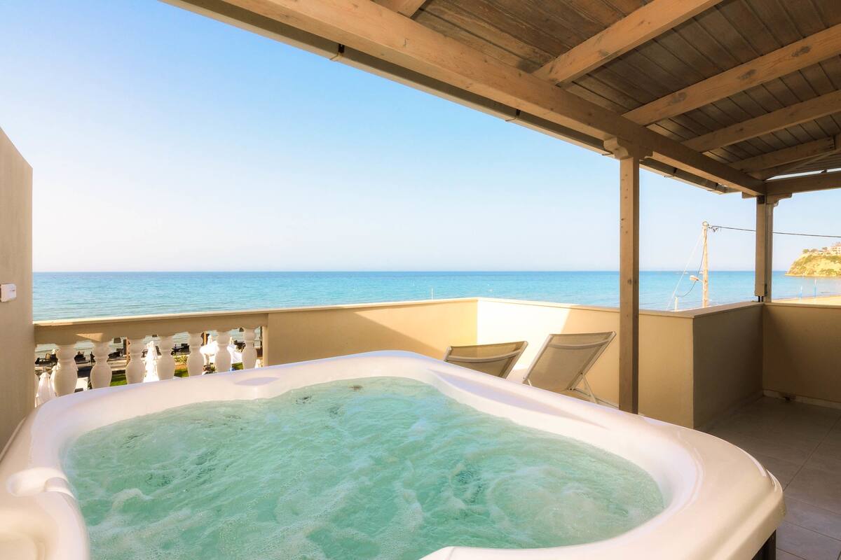 A hot tub on a balcony with a view of the sea.