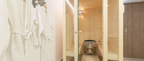 A wooden sauna with a glass door, wooden benches, and a bench heater.