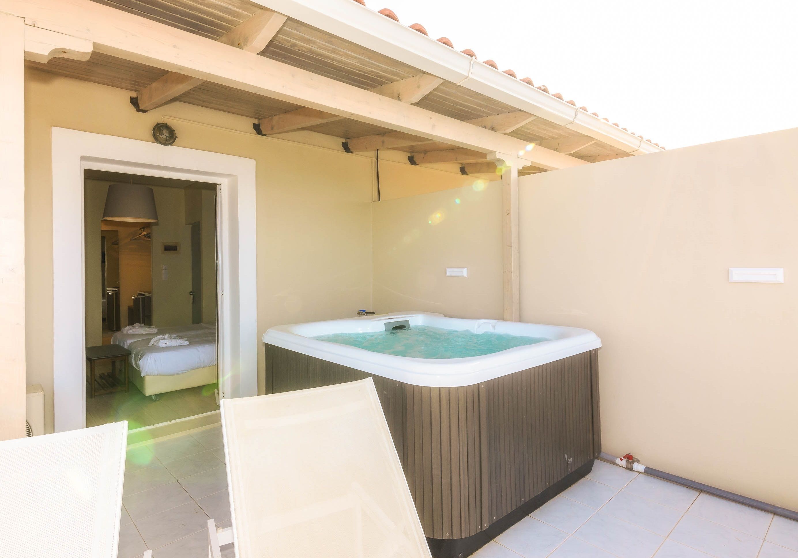 Ein Spa-Raum mit Whirlpool, Bett und Duschbereich.