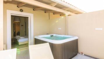 Ein Spa-Raum mit Whirlpool, Bett und Duschbereich.