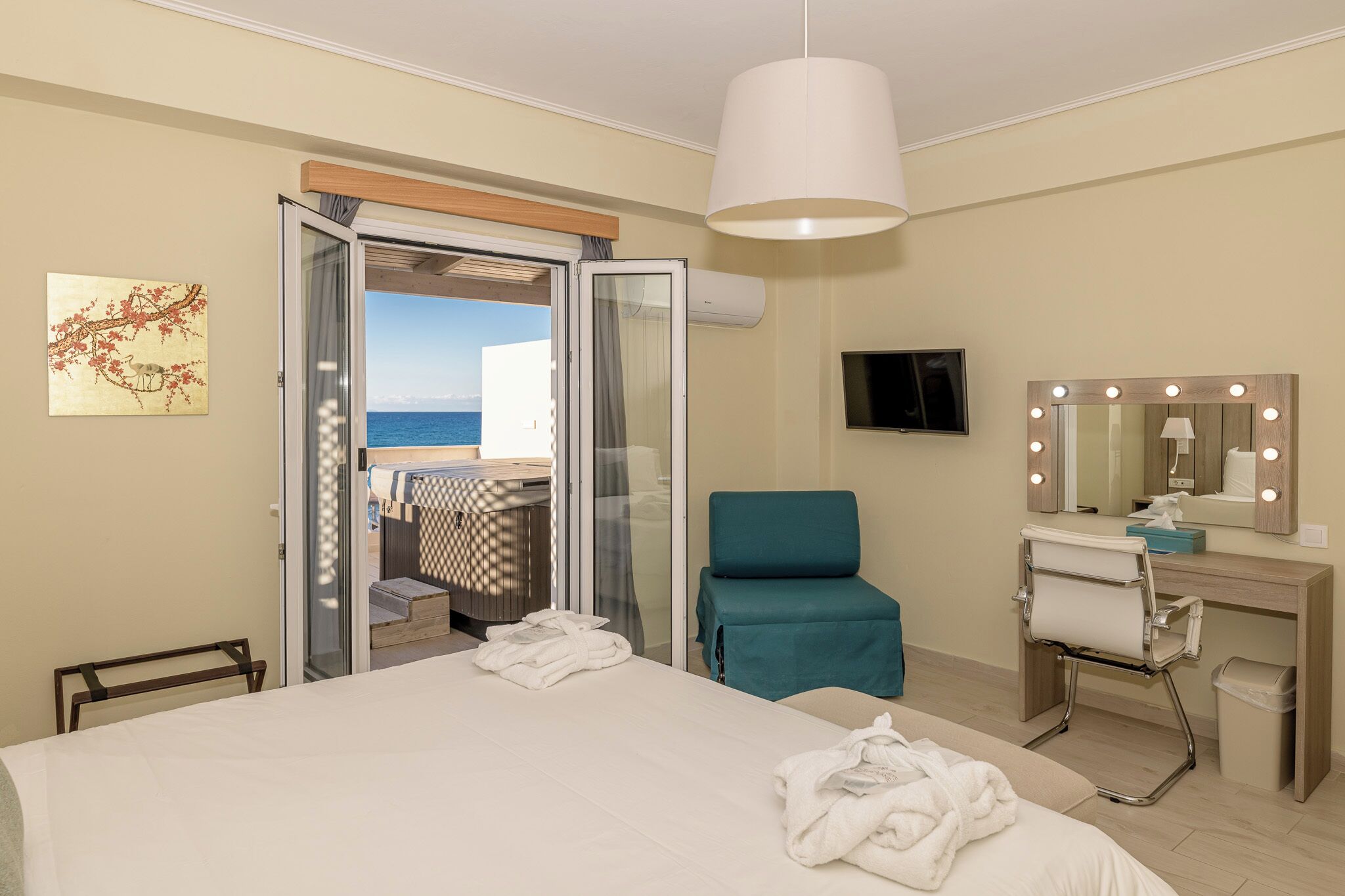 Une chambre d’hôtel comprenant un lit, une chaise, une coiffeuse avec un miroir et un téléviseur.