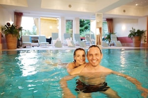 Una piscina techada, sillones reclinables de piscina