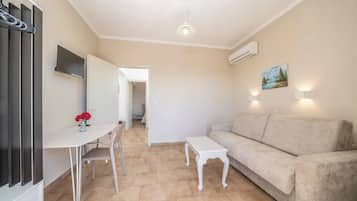 Una sala de estar con un sofá, una mesa de centro y un televisor montado en la pared.