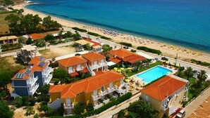Resort costeiro com vários edifícios, piscina e praia.