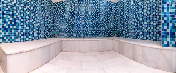 A curved marble bench with a tiled wall in the background. - Grand Work Hotel (Ankara)