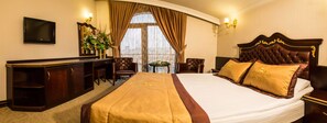 A hotel room with a large bed, a desk, a chair, a television, and a window with curtains. - Grand Work Hotel (Ankara)
