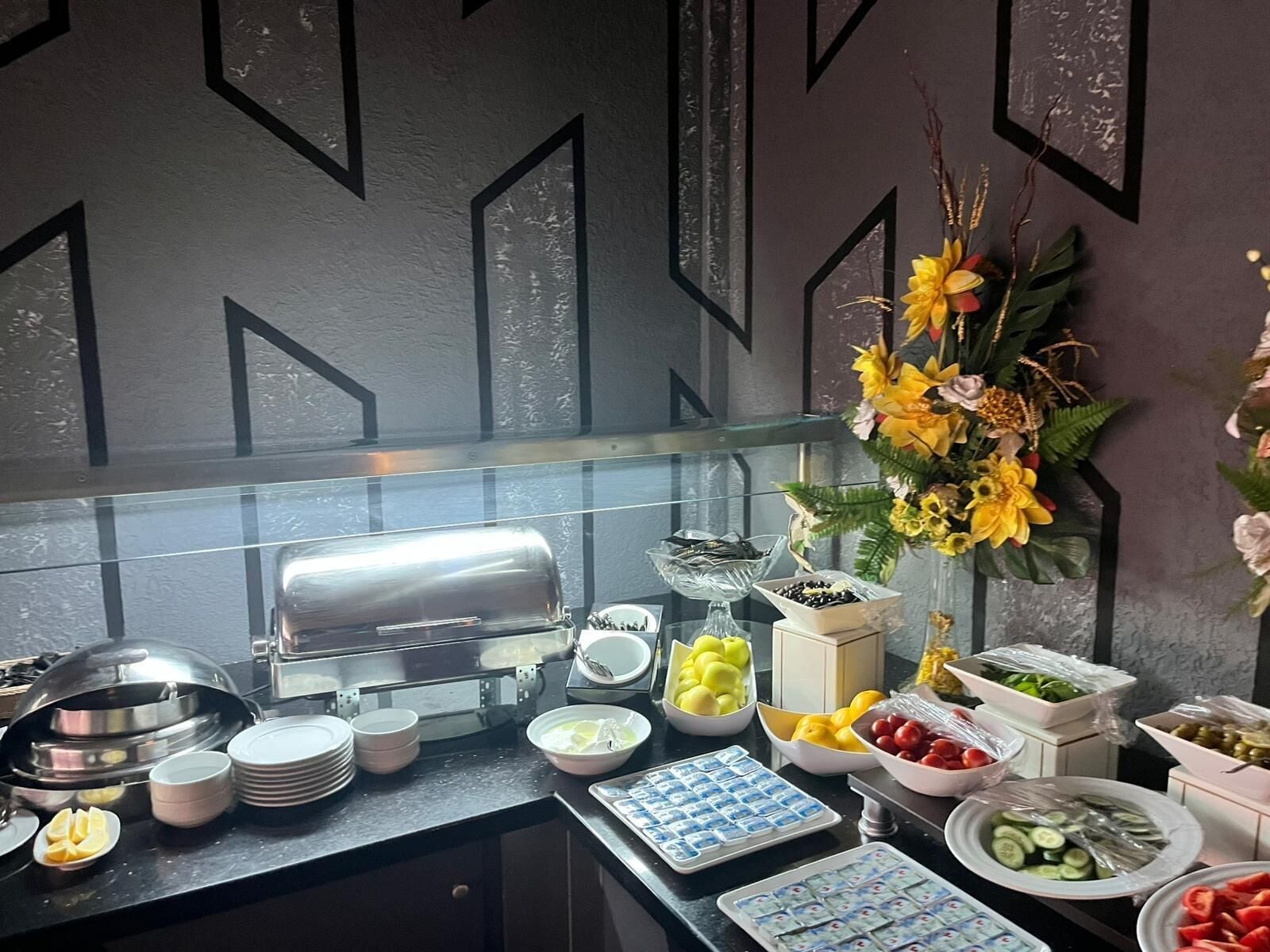A buffet setup with various food items and dishes.
