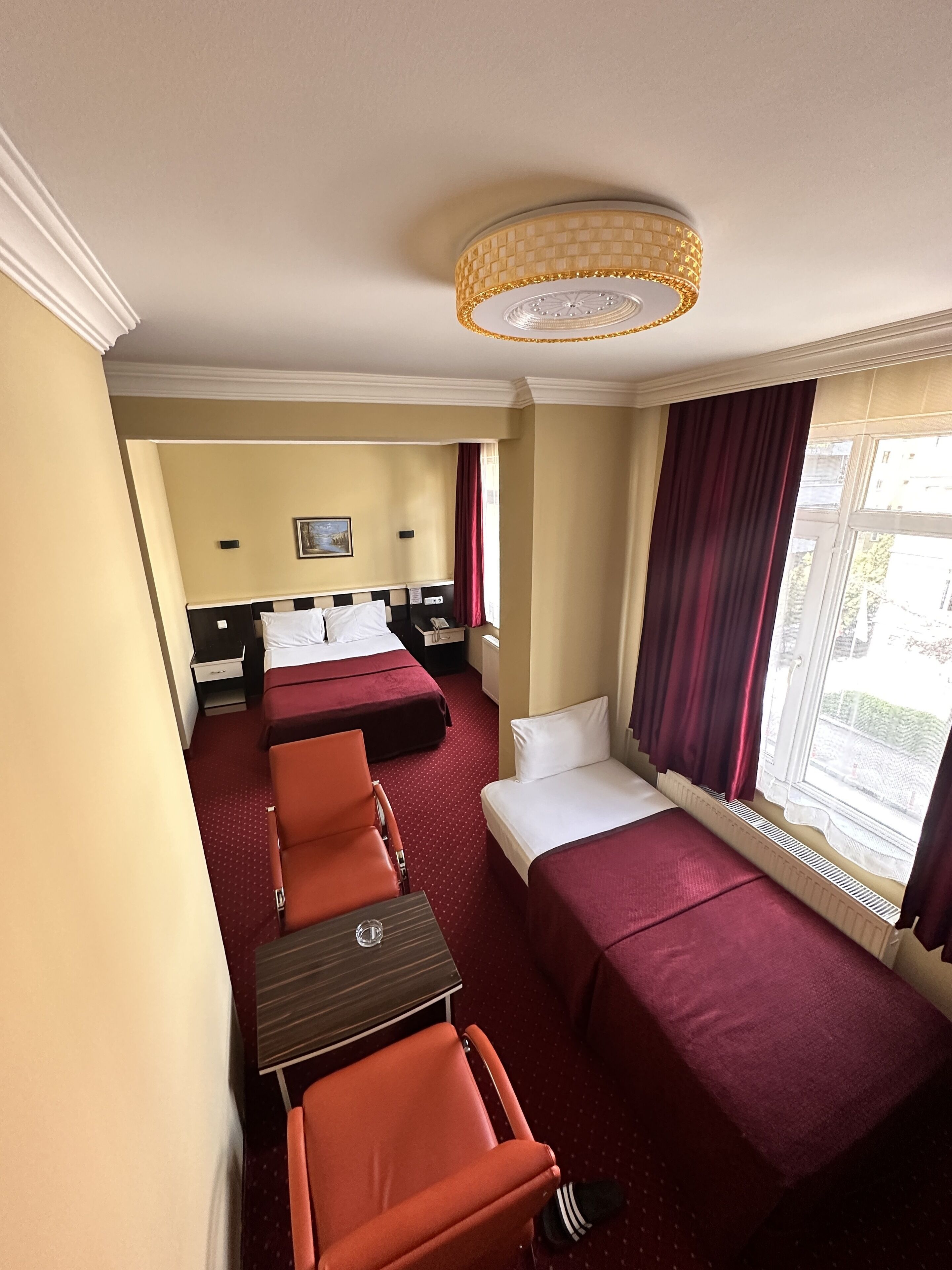 A hotel room with two beds, a table, and chairs.