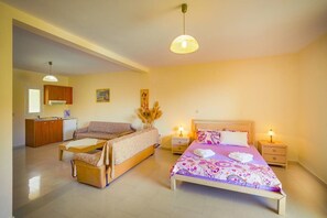 Un dormitorio con cama, sofá, mesita, mesita de noche y armario.