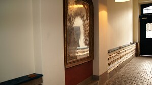 A hallway with a mirror, a wooden bench, and a tiled floor. - Altstadthaus Cityappartements (Graz)