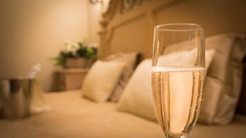 A clear glass of champagne in a well-lit room with a sofa and decorative pillows.