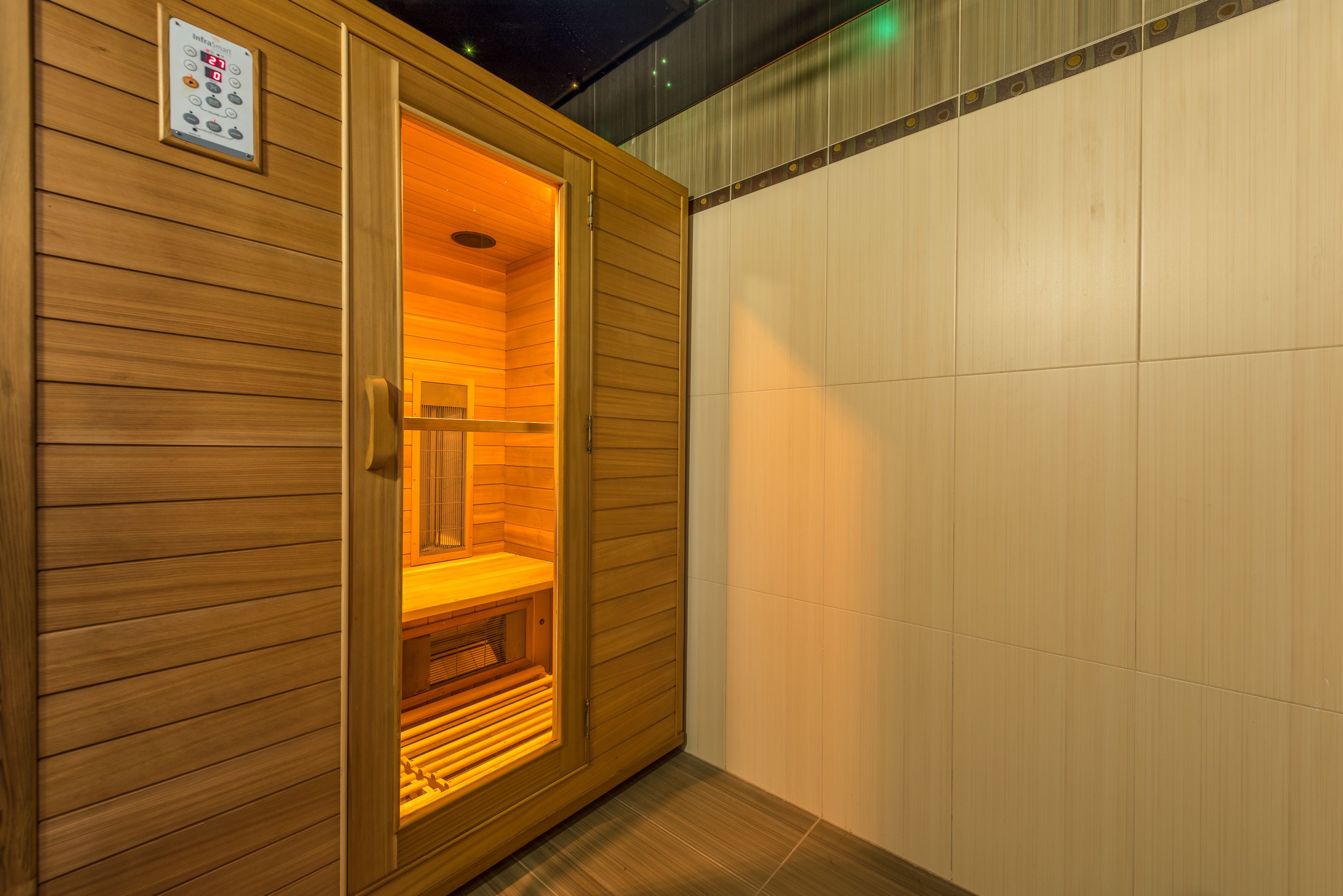 Una sauna con revestimiento de madera y un panel de control en la pared.