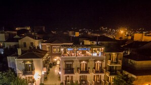 Een hotel met meerdere verdiepingen, een centrale binnenplaats, balkons en een terras op het dak.