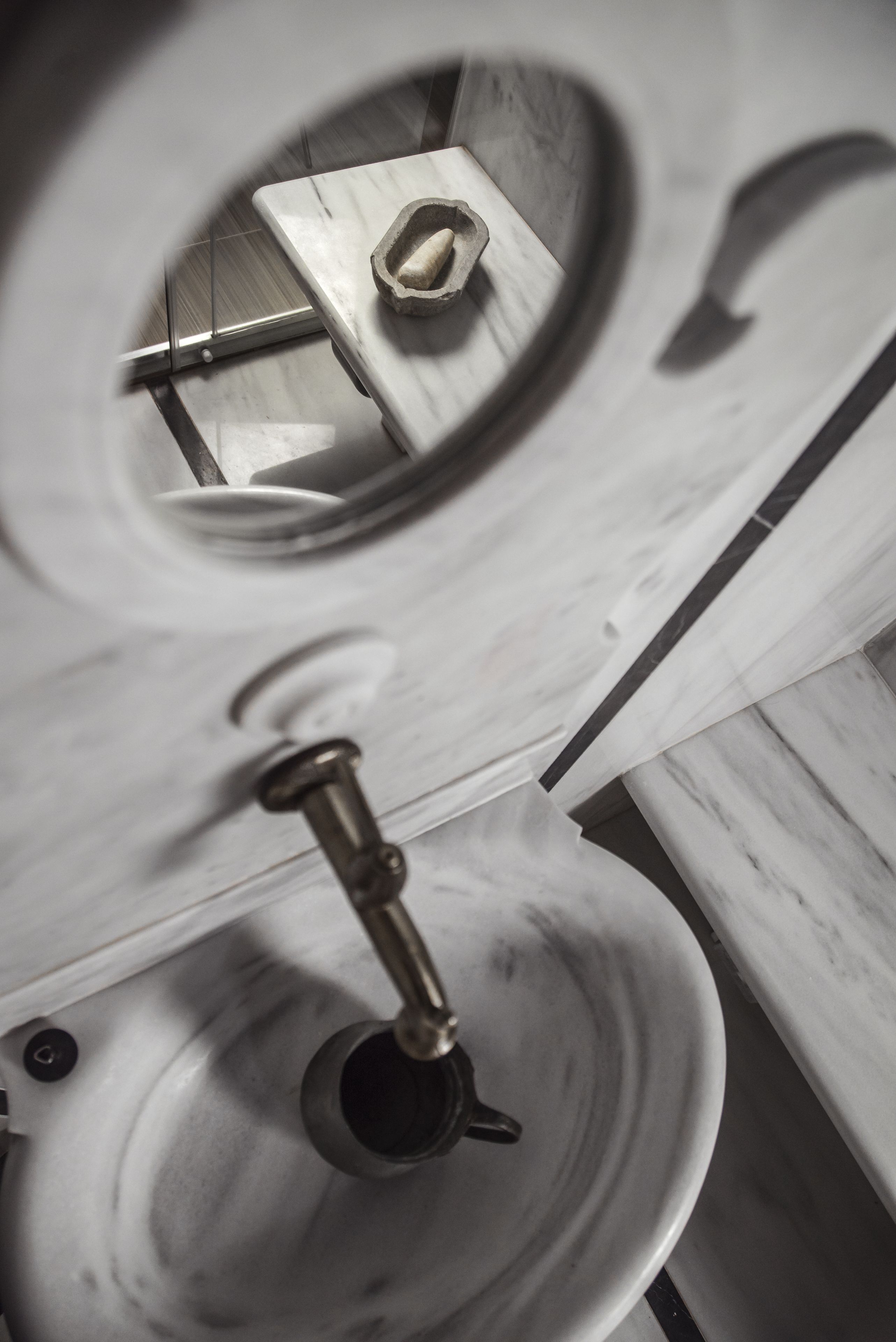 A toilet with a marble sink and a mirror.