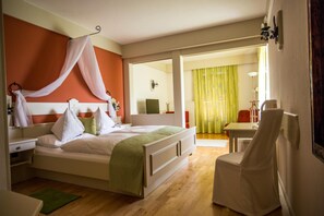 Een hotelkamer met een bed, nachtkastje, stoel en uitzicht op de eetruimte.