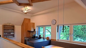 Una cocina compacta con armarios de madera, una isla integrada y un comedor con mesa y sillas.