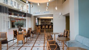 Un vaste espace intérieur aménagé avec différents types de sièges, notamment des tables et des chaises, ainsi qu’un bar doté d’étagères remplies de bouteilles.