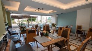 Un restaurant avec une terrasse, des tables, des chaises et une vue sur la ville.