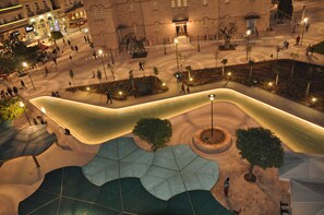 An aerial view of a public square with a curved pathway, trees, and street lamps. - Morfeas Hotel (Argos-Mykines)