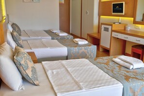 Een hotelkamer met twee bedden, een bureau, een kledingkast en een televisie.