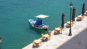 A boat docked at a waterfront café with outdoor seating.