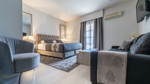 Une chambre d’hôtel moderne équipée d’un lit, d’un canapé, d’une table basse et d’un grand miroir.