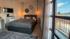 Une chambre à coucher avec un lit, une télévision, une horloge et une fenêtre donnant sur l’extérieur.