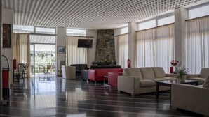 Un hall amplio con chimenea de piedra, asientos cómodos y ventanas grandes.