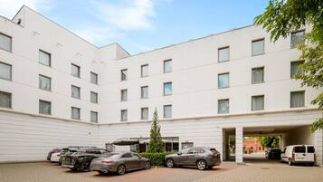 A multi-story building with a parking area in front.
