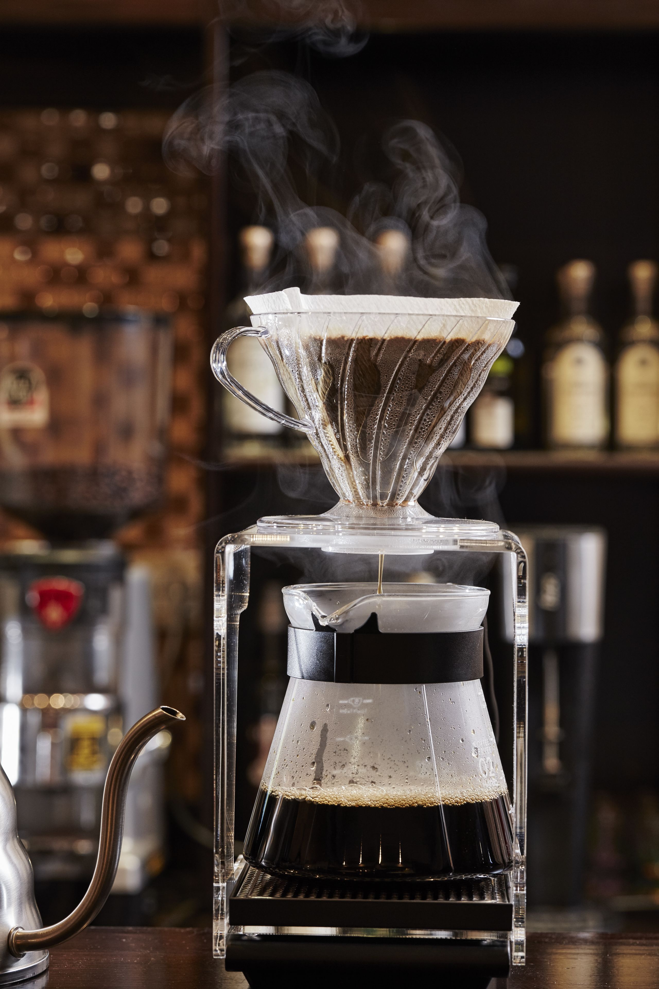 Una cafetera con vapor saliendo, sobre una superficie de madera.