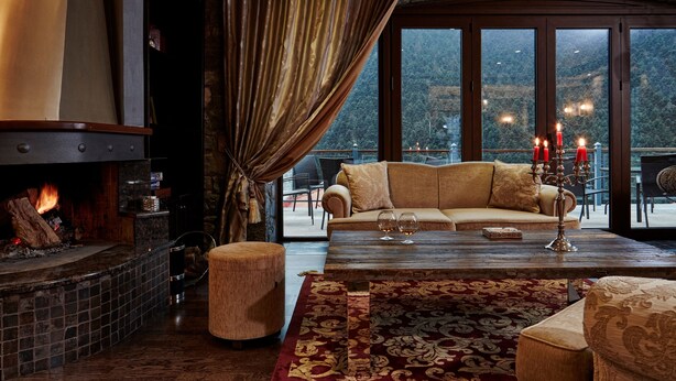 A cozy living room with a fireplace, a sofa, and a coffee table.