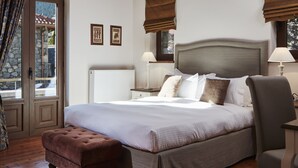 A bedroom with a wooden ceiling, a bed with a headboard, a nightstand, a chair, and a window with curtains.