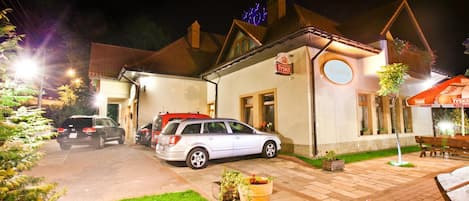Un edificio con un letrero que dice 'TYSKIE' y un coche estacionado adelante.
