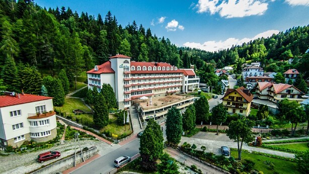 A hotel with a red roof, multiple floors, and a central courtyard. - Geovita Krynica Zdroj (Krynica-Zdroj)